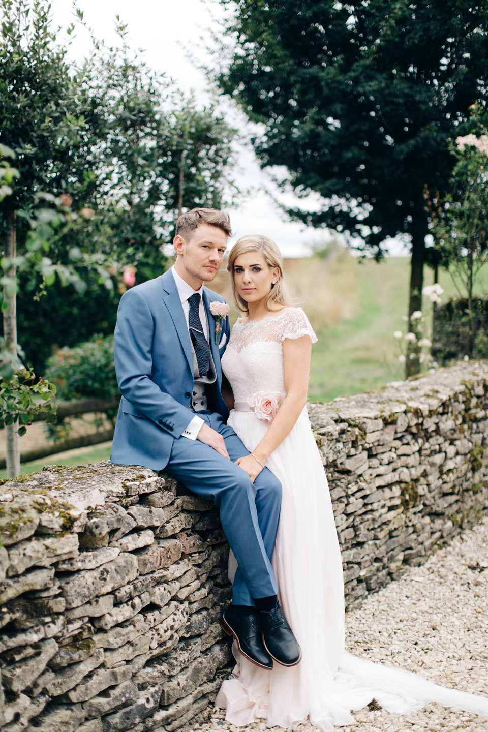 Bride Melanie wears the 'fleur' gown by Naomi Neoh for her Cripps Barn wedding. Her bridesmaids are most pretty in soft pink by 'For Her & For Him'. Images by M&J Photography.