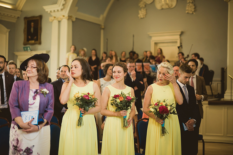 Bride Kate wears a Grace Loves Lace gown for her colourful and Fiesta inspired village hall wedding. Photography by Tom Ravenshear.