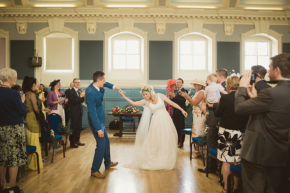 Bride Kate wears a Grace Loves Lace gown for her colourful and Fiesta inspired village hall wedding. Photography by Tom Ravenshear.