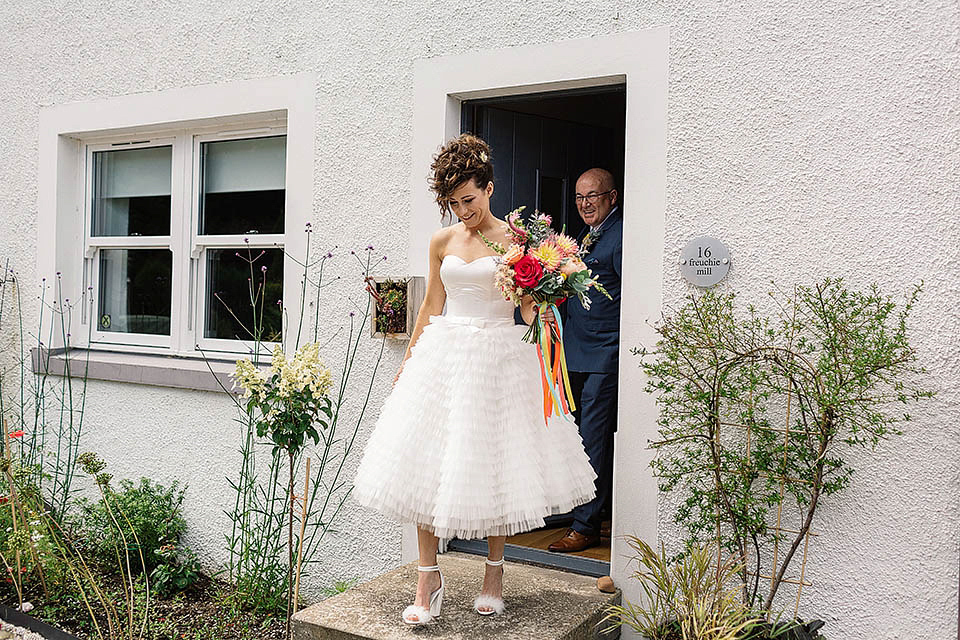 Audrey wore a 1950's inspired tiered wedding dress by Mooshki Bridal for her outdoor wedding in Scotland. The colourful and quirky wedding ceremony was held within the ruins of a chapel. Photography by Paul Joseph.