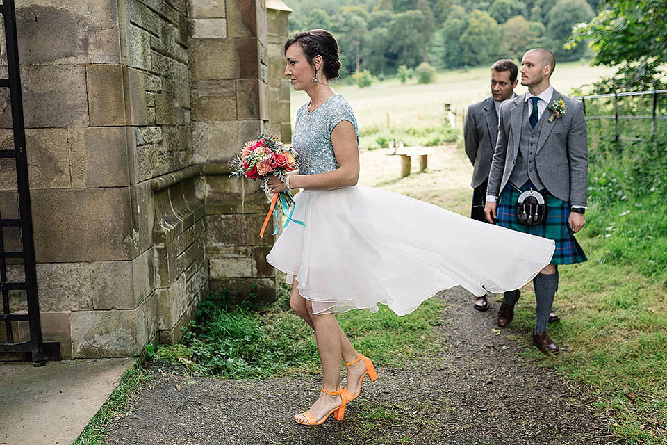 Audrey wore a 1950's inspired tiered wedding dress by Mooshki Bridal for her outdoor wedding in Scotland. The colourful and quirky wedding ceremony was held within the ruins of a chapel. Photography by Paul Joseph.