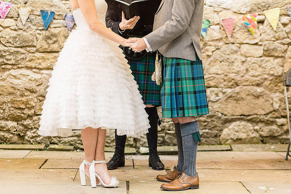 Audrey wore a 1950's inspired tiered wedding dress by Mooshki Bridal for her outdoor wedding in Scotland. The colourful and quirky wedding ceremony was held within the ruins of a chapel. Photography by Paul Joseph.