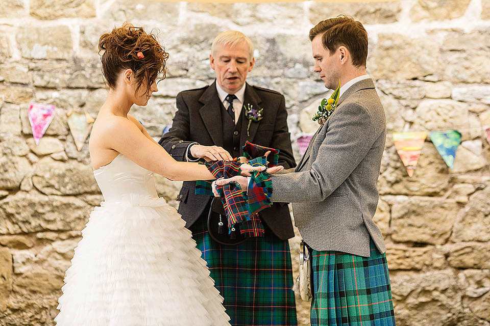 Audrey wore a 1950's inspired tiered wedding dress by Mooshki Bridal for her outdoor wedding in Scotland. The colourful and quirky wedding ceremony was held within the ruins of a chapel. Photography by Paul Joseph.