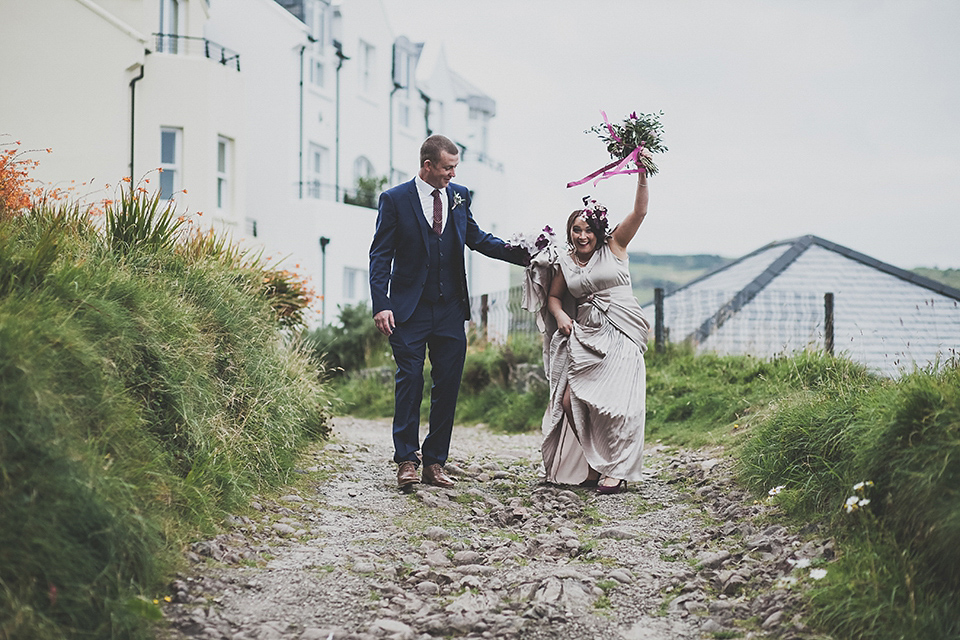 Tara wore a pleated dress in silk with a floral veil for her beautiful coastal wedding at Cushendall Golf Club in Northern Ireland. Photography by Mary McQuillan.