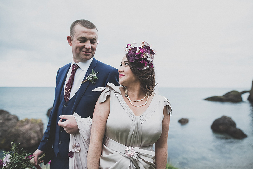 Tara wore a pleated dress in silk with a floral veil for her beautiful coastal wedding at Cushendall Golf Club in Northern Ireland. Photography by Mary McQuillan.