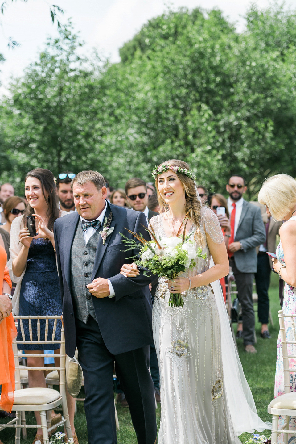 Bride Emma wore Eden by Jenny Packham, a fishtail plait and flowers in her hair for her ourdoor wedding at Baxby Manor. Photography by Sarah Folega.