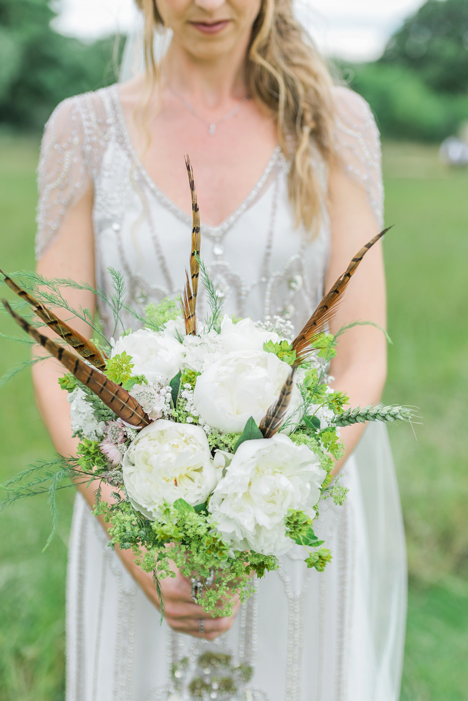 Bride Emma wore Eden by Jenny Packham, a fishtail plait and flowers in her hair for her ourdoor wedding at Baxby Manor. Photography by Sarah Folega.