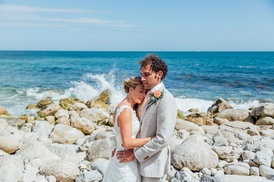 Bride Sarah wore an Essence of Australia gown and flowers in her hair for her wedding by the sea in Dorset. Photography by Charlotte Bryer Ash.
