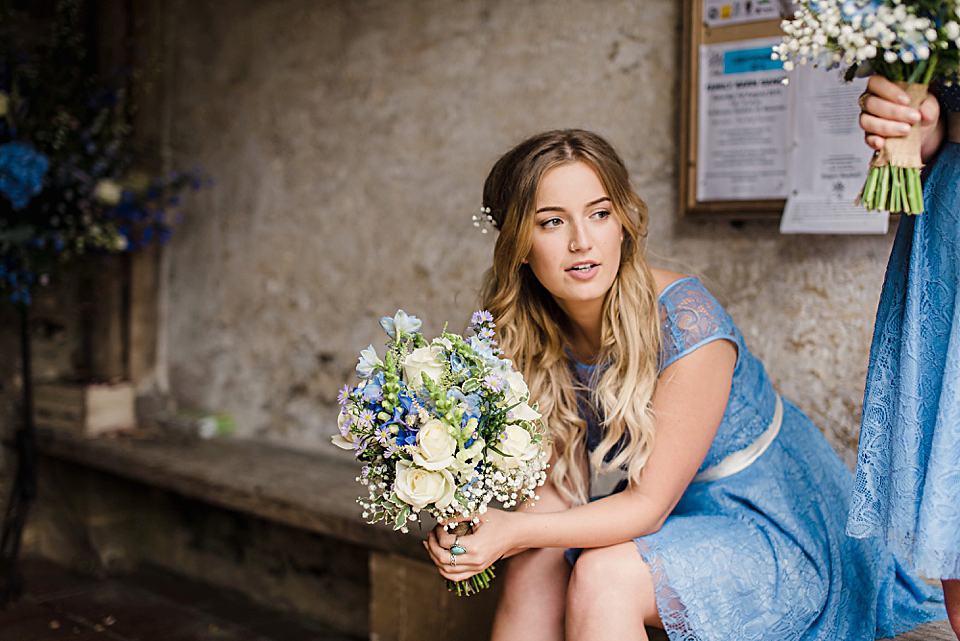 Bride Daisy wore a Stella York gown for her pale blue and flower filled Summer wedding in the English countryside. Photography by Faye Cornhill.