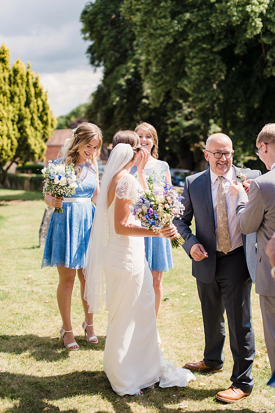 Bride Daisy wore a Stella York gown for her pale blue and flower filled Summer wedding in the English countryside. Photography by Faye Cornhill.