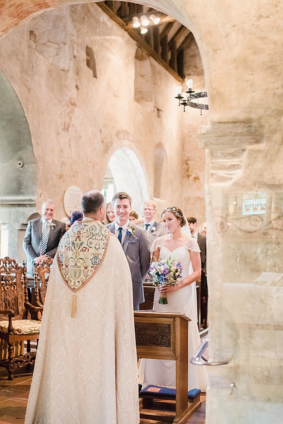 Bride Daisy wore a Stella York gown for her pale blue and flower filled Summer wedding in the English countryside. Photography by Faye Cornhill.