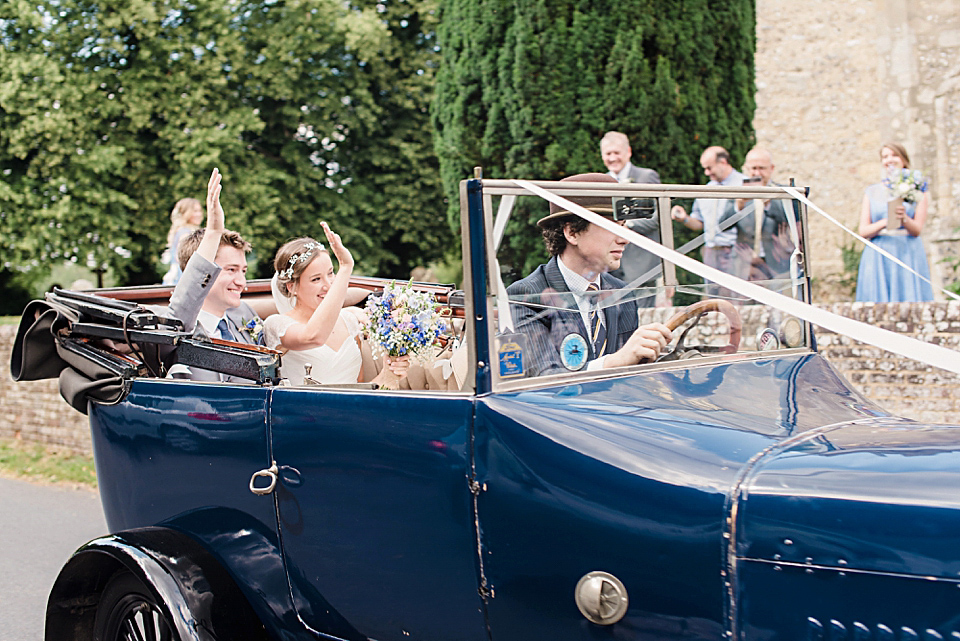 Bride Daisy wore a Stella York gown for her pale blue and flower filled Summer wedding in the English countryside. Photography by Faye Cornhill.