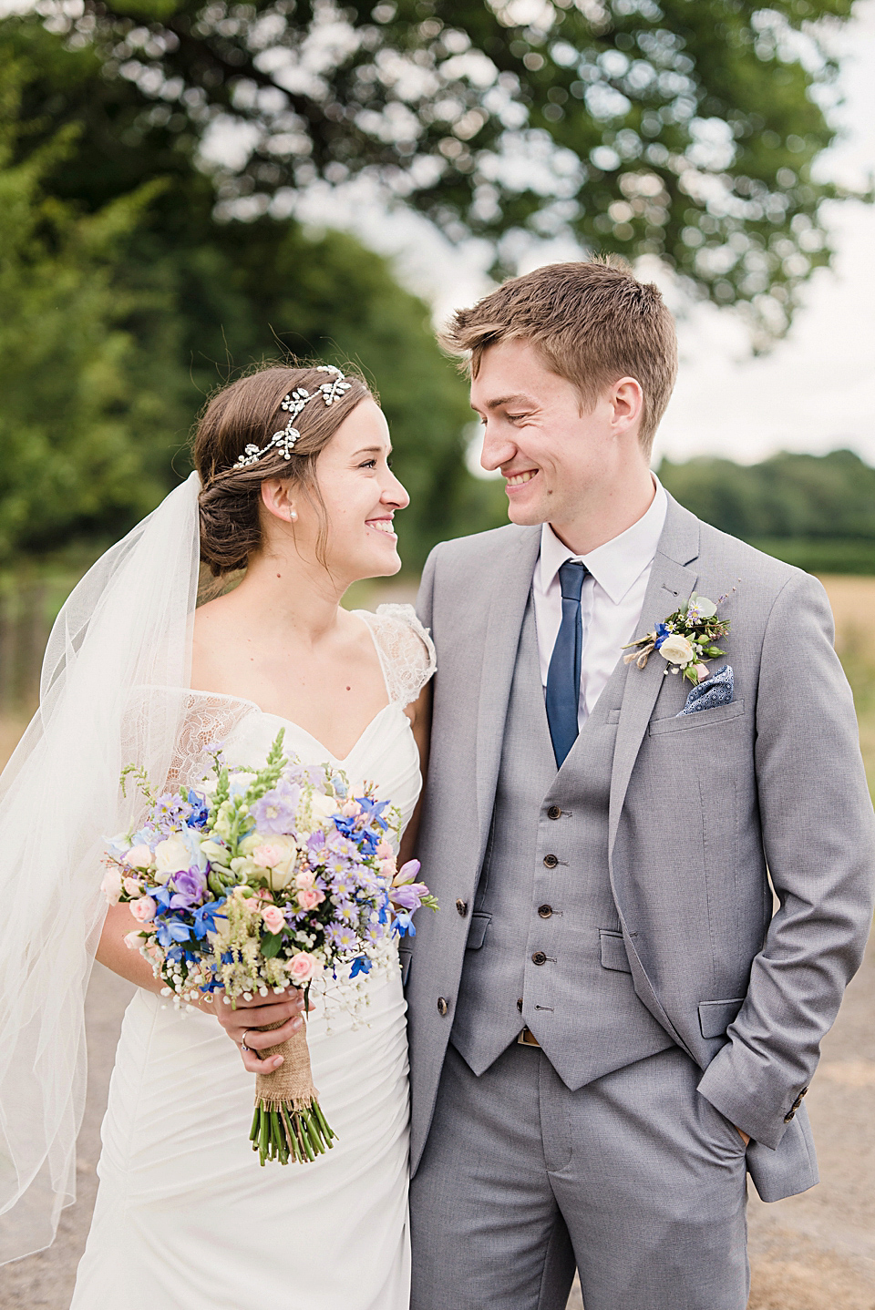 Bride Daisy wore a Stella York gown for her pale blue and flower filled Summer wedding in the English countryside. Photography by Faye Cornhill.