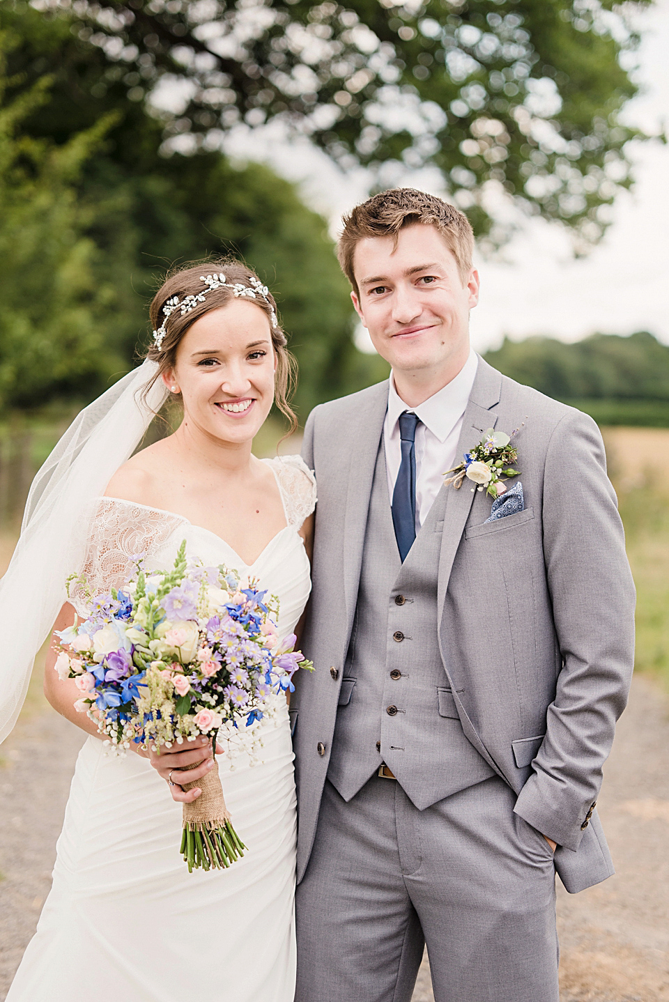 Bride Daisy wore a Stella York gown for her pale blue and flower filled Summer wedding in the English countryside. Photography by Faye Cornhill.