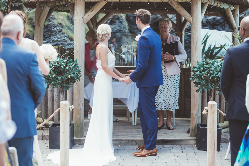 Charlotte wears a Charlotte Simpson gown for her wedding by the sea in Devon. Photography by Philippa James.