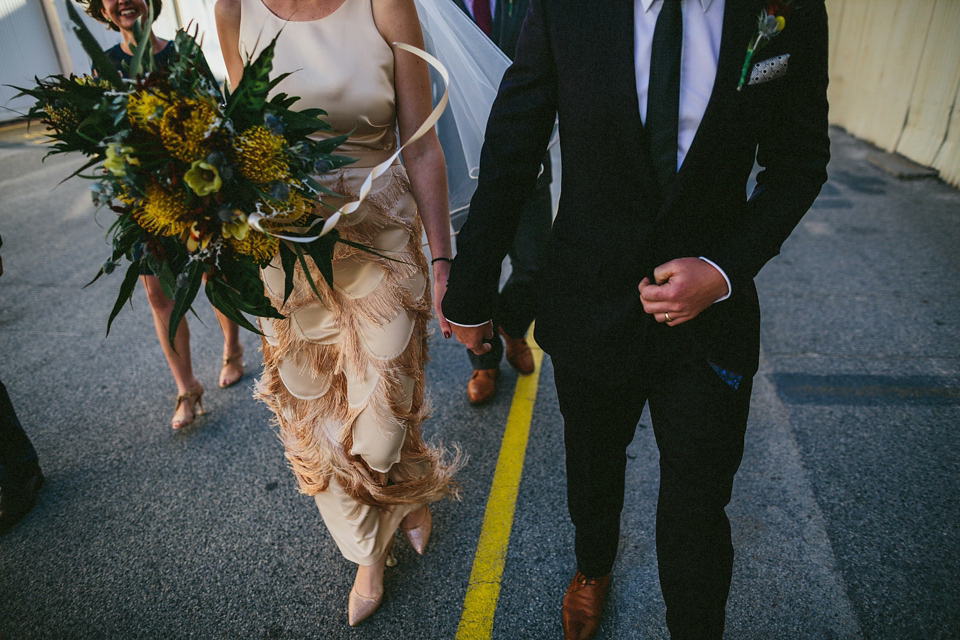 A 1920's flapper inspired wedding dress with tassels. Photography by Through The Woods We Ran.