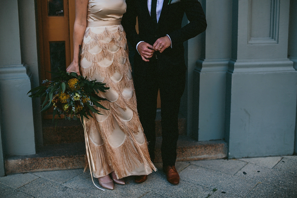 A 1920's flapper inspired wedding dress with tassels. Photography by Through The Woods We Ran.