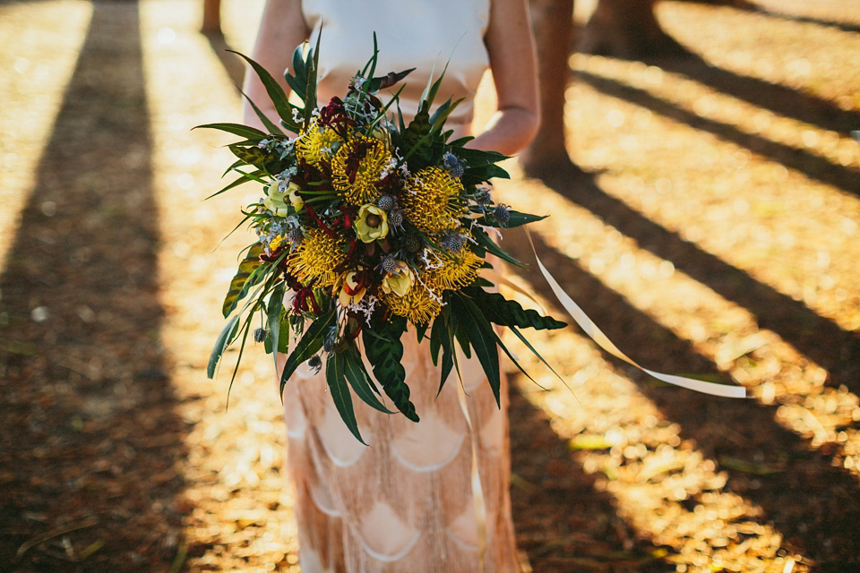 A 1920's flapper inspired wedding dress with tassels. Photography by Through The Woods We Ran.