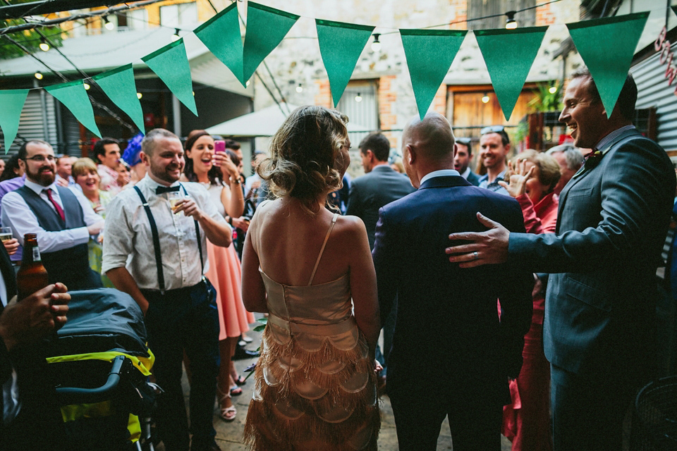 A 1920's flapper inspired wedding dress with tassels. Photography by Through The Woods We Ran.