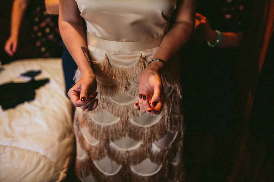 A 1920's flapper inspired wedding dress with tassels. Photography by Through The Woods We Ran.