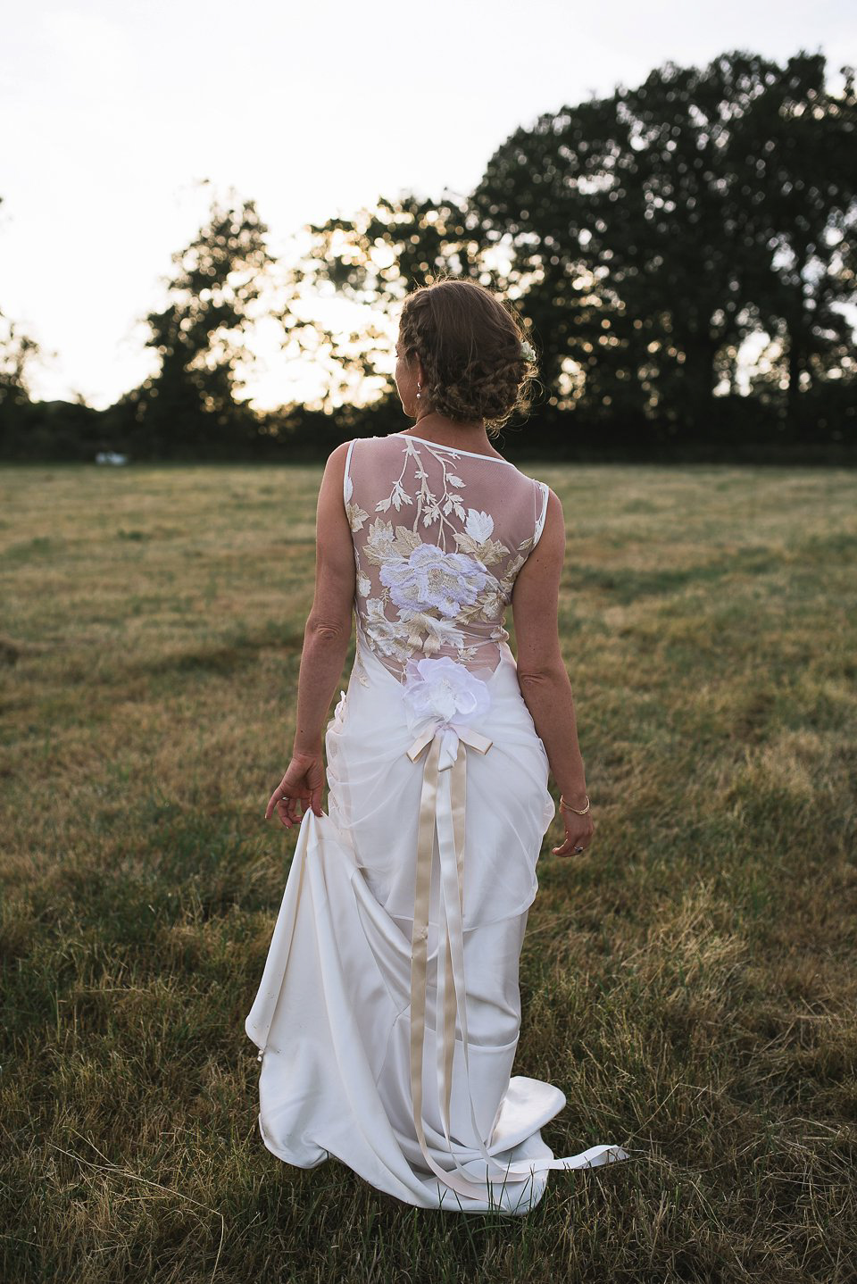 Bryony wore a gown with a floral back by Claire Pettibone from Blackburn Bridal for her Summer wedding held at her husband's family home. Photography by Kristian Leven.