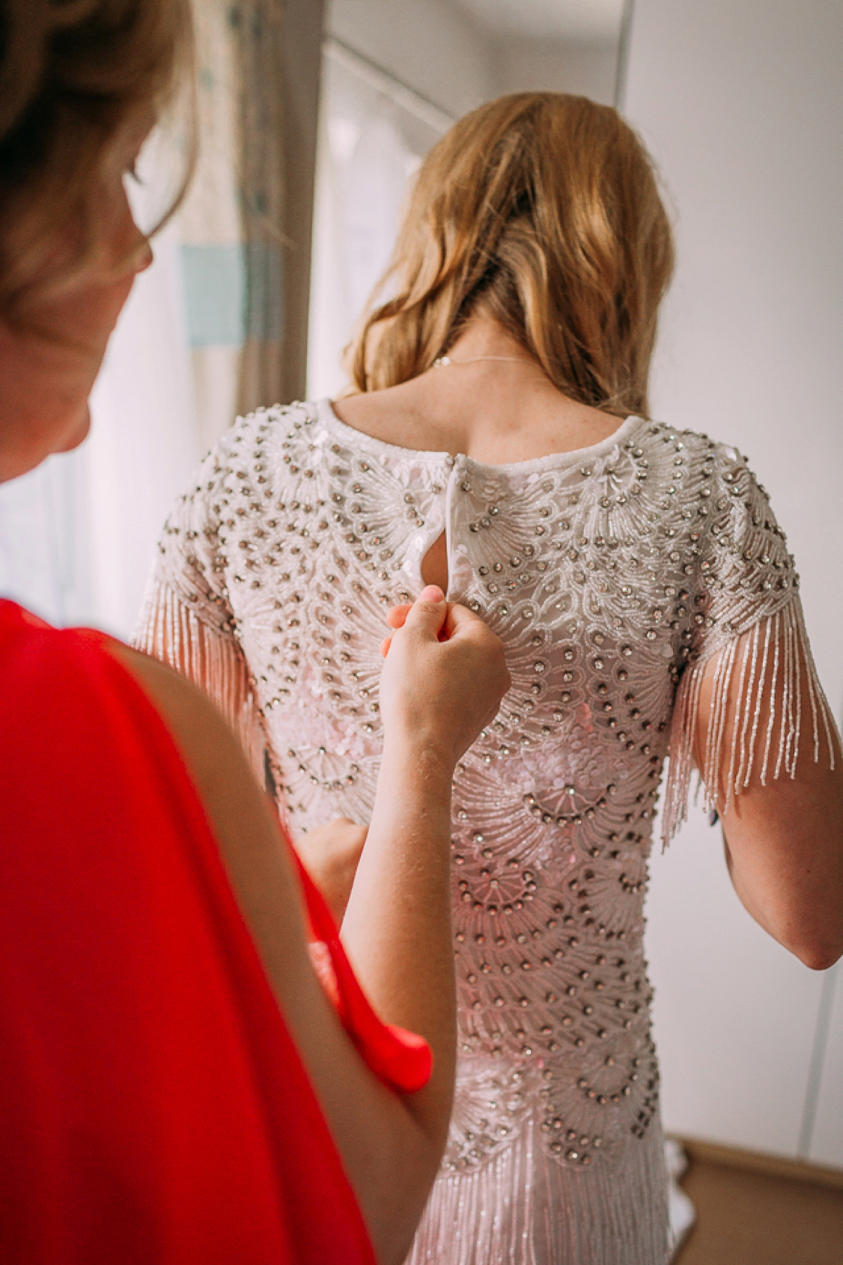 A beaded and tassled Eliza Jane Howell gown and maids in coral pink. Miki Photography.