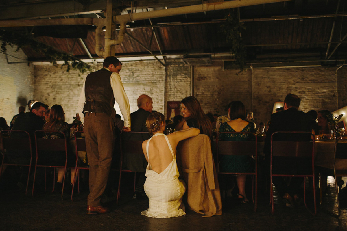 The bride wears a 1920's inspired drop waist gown by Charlie Brear for her cool and quirky wedding at MC Motors in East London. Photography by Emilie White.