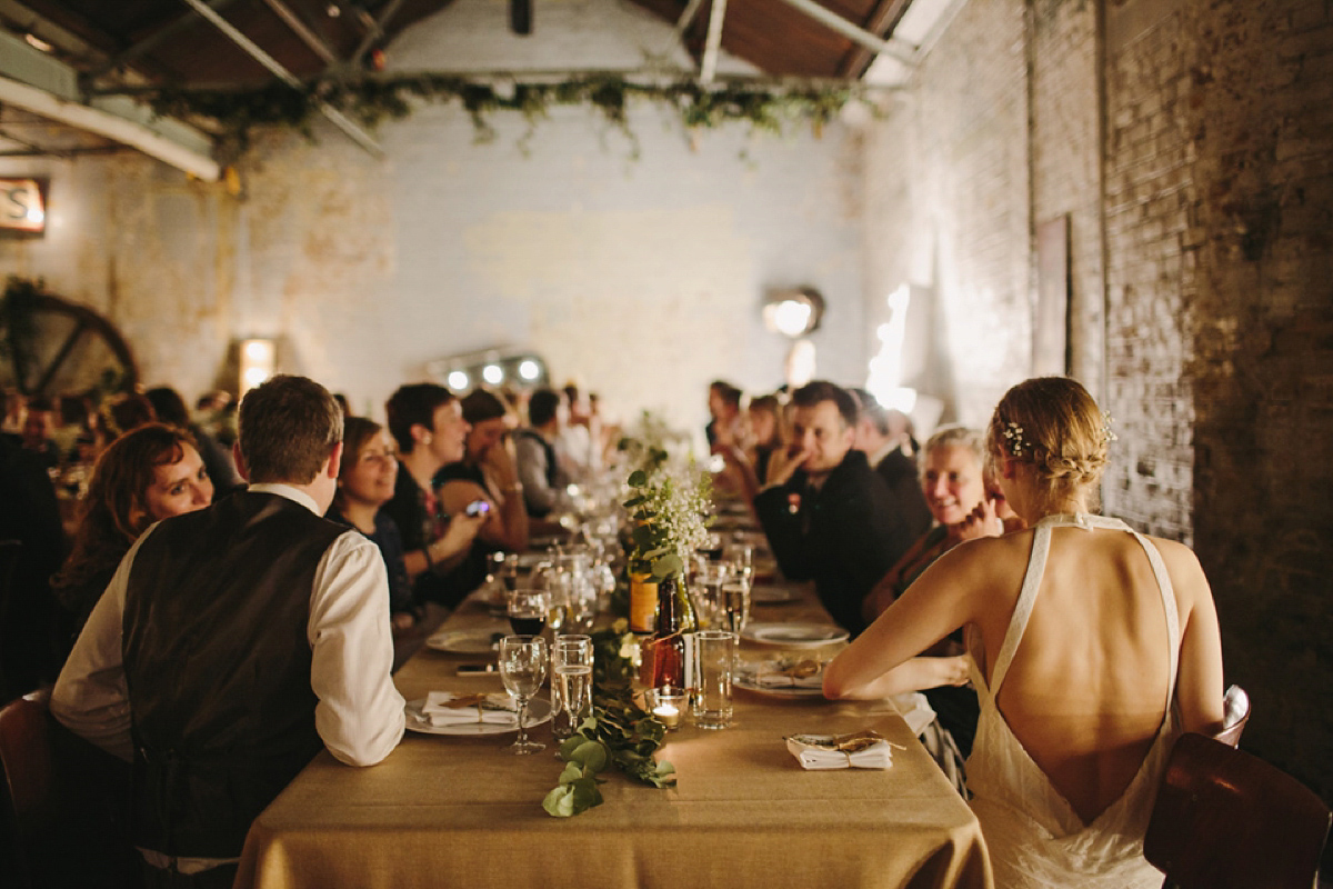 The bride wears a 1920's inspired drop waist gown by Charlie Brear for her cool and quirky wedding at MC Motors in East London. Photography by Emilie White.