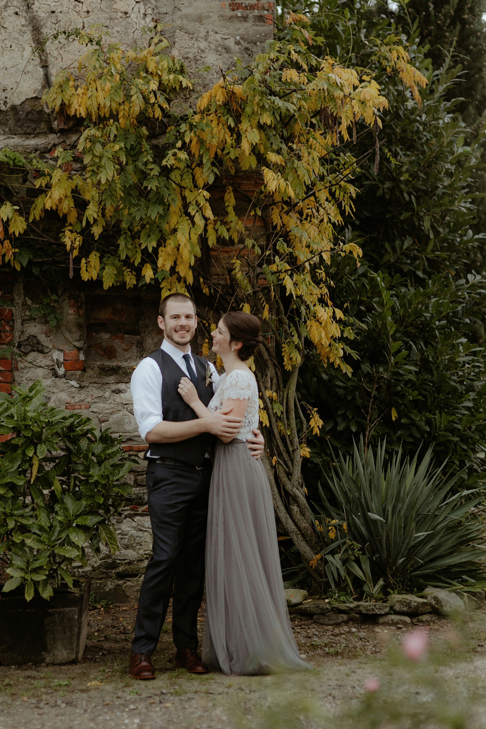 The bride wears a Jenny Yoo gown in soft grey tulle for her rustic Italian villa wedding. Photography by Cinzia Bruschini.