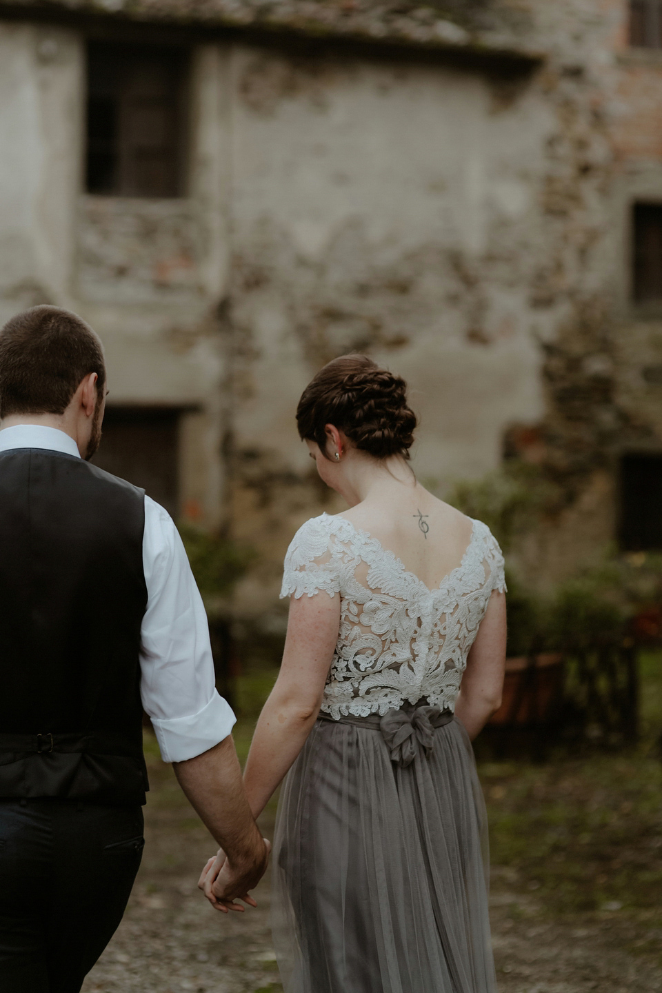 The bride wears a Jenny Yoo gown in soft grey tulle for her rustic Italian villa wedding. Photography by Cinzia Bruschini.