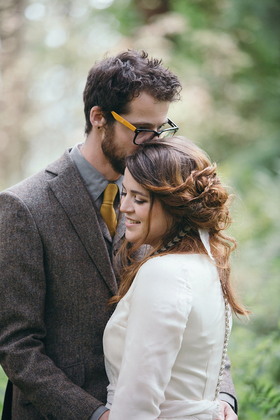 A tweed jacket and feathers in her hair for a boho bride and her eclectic woodland wedding. Images by Mirrorbox Photography.