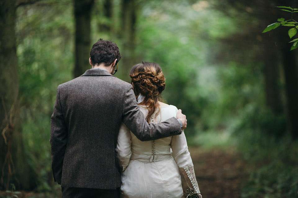 A tweed jacket and feathers in her hair for a boho bride and her eclectic woodland wedding. Images by Mirrorbox Photography.