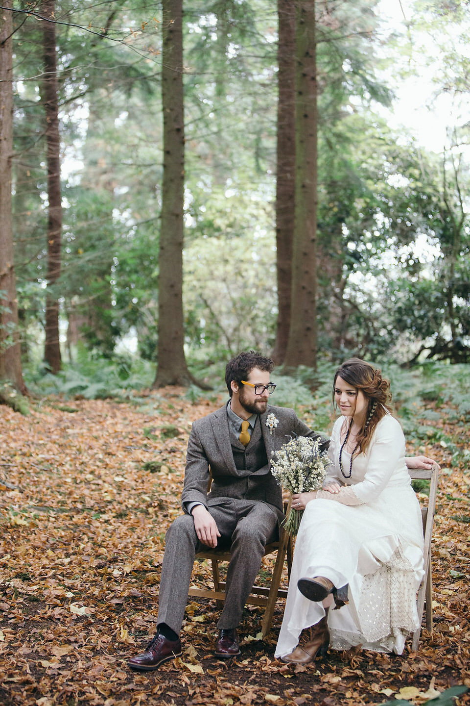 A tweed jacket and feathers in her hair for a boho bride and her eclectic woodland wedding. Images by Mirrorbox Photography.