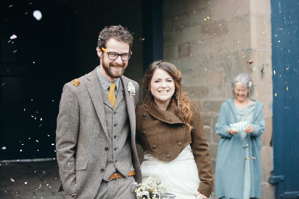 A tweed jacket and feathers in her hair for a boho bride and her eclectic woodland wedding. Images by Mirrorbox Photography.