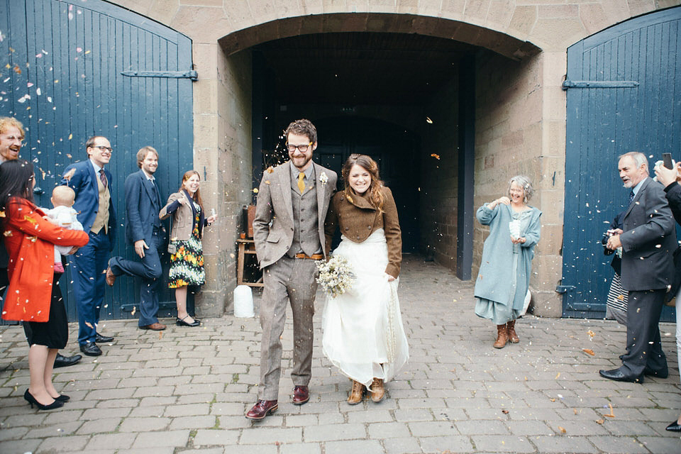 A tweed jacket and feathers in her hair for a boho bride and her eclectic woodland wedding. Images by Mirrorbox Photography.