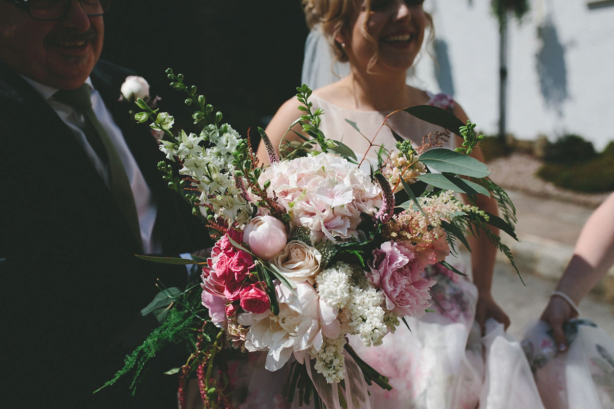 A floral wedding dress by Sassi Holford for a Summer wedding in the Peak District. Flowers by Campbell's Flowers, photography by Ellie Grace.