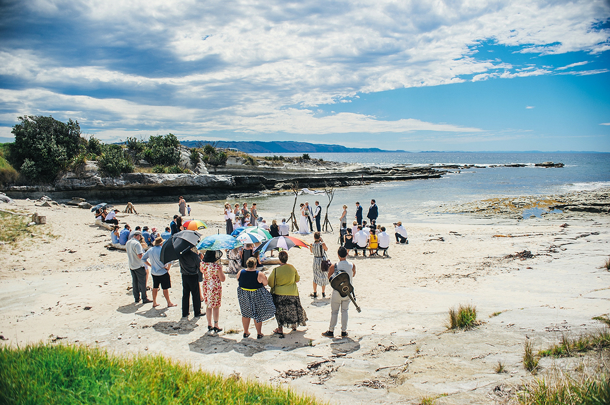 Suzy wore a stunning ombre/dip dye dress for her barefoot beach wedding in New Zealand. Photography by Meredith Lord.