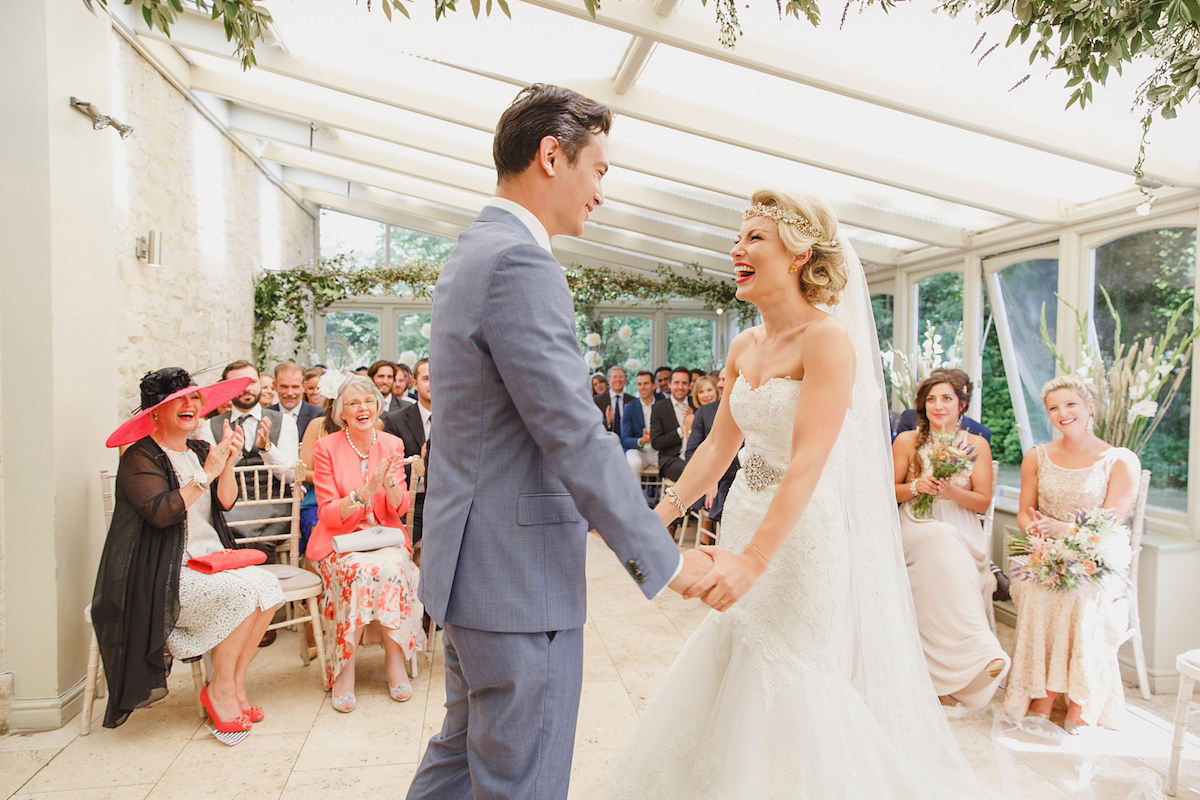 Victoria wears a Pronovias gown with a cathedral length veil for her relaxed, fun and colourful English country garden wedding in the Cotswolds. Photography by Sarah Ann Wright.