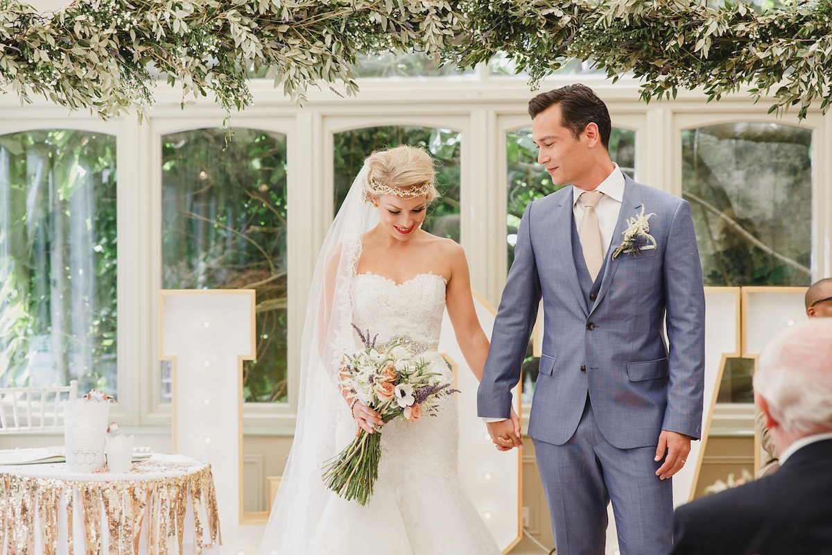 Victoria wears a Pronovias gown with a cathedral length veil for her relaxed, fun and colourful English country garden wedding in the Cotswolds. Photography by Sarah Ann Wright.