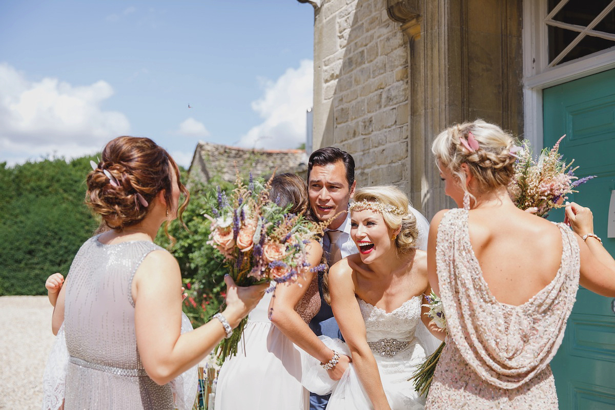 Victoria wears a Pronovias gown with a cathedral length veil for her relaxed, fun and colourful English country garden wedding in the Cotswolds. Photography by Sarah Ann Wright.