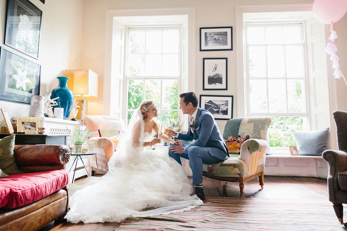 Victoria wears a Pronovias gown with a cathedral length veil for her relaxed, fun and colourful English country garden wedding in the Cotswolds. Photography by Sarah Ann Wright.