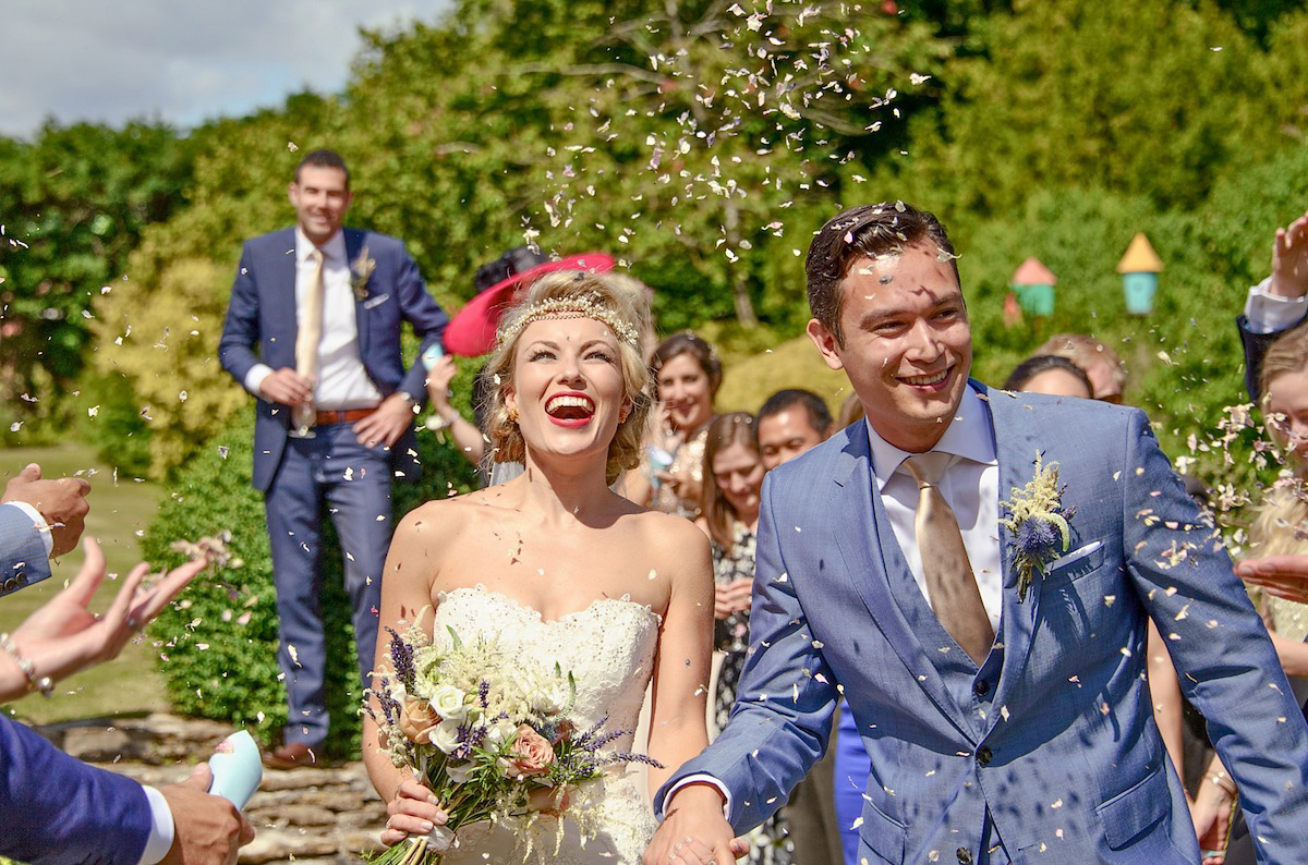 Victoria wears a Pronovias gown with a cathedral length veil for her relaxed, fun and colourful English country garden wedding in the Cotswolds. Photography by Sarah Ann Wright.