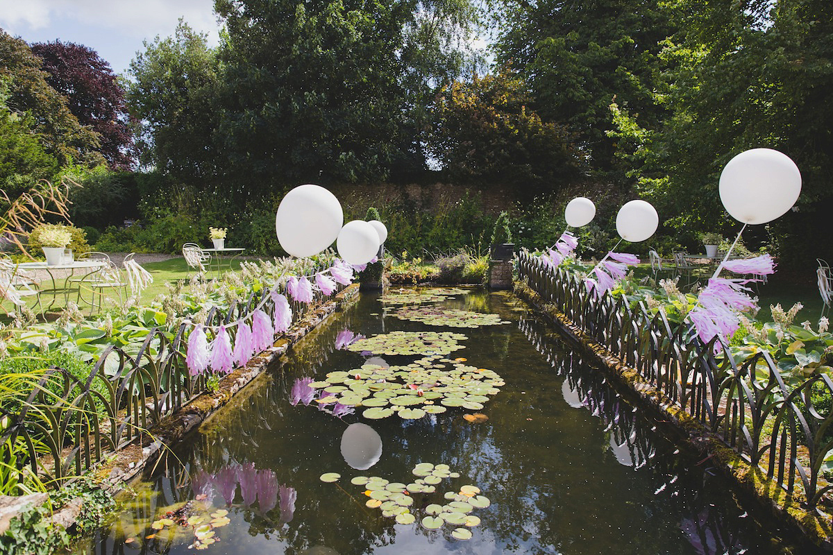 Victoria wears a Pronovias gown with a cathedral length veil for her relaxed, fun and colourful English country garden wedding in the Cotswolds. Photography by Sarah Ann Wright.