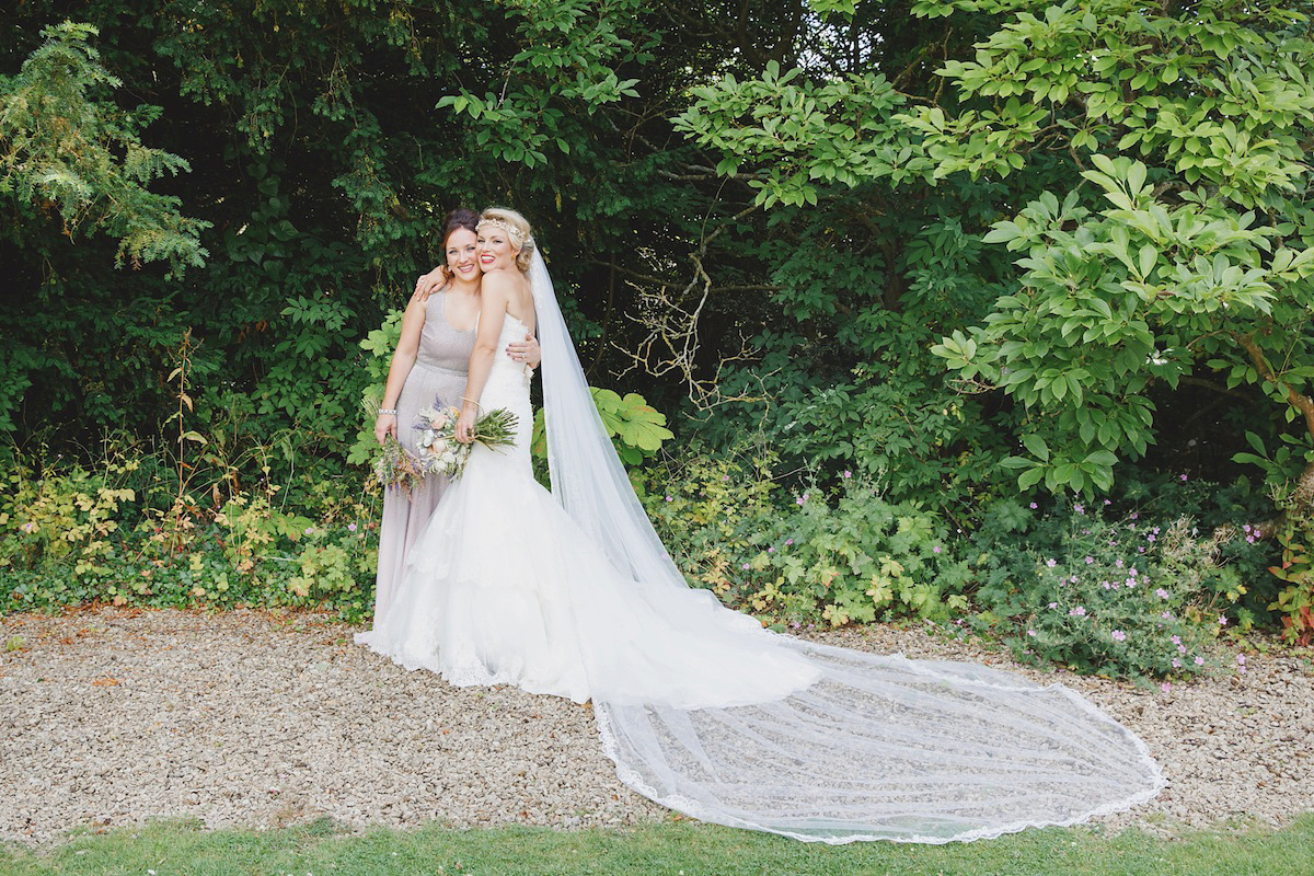 Victoria wears a Pronovias gown with a cathedral length veil for her relaxed, fun and colourful English country garden wedding in the Cotswolds. Photography by Sarah Ann Wright.