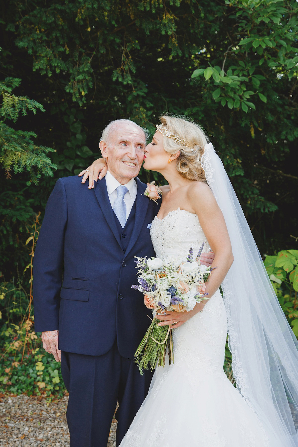 Victoria wears a Pronovias gown with a cathedral length veil for her relaxed, fun and colourful English country garden wedding in the Cotswolds. Photography by Sarah Ann Wright.