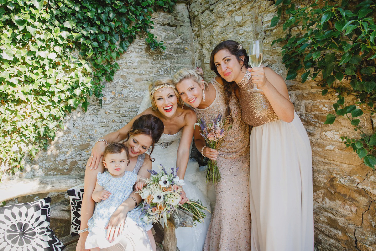 Victoria wears a Pronovias gown with a cathedral length veil for her relaxed, fun and colourful English country garden wedding in the Cotswolds. Photography by Sarah Ann Wright.