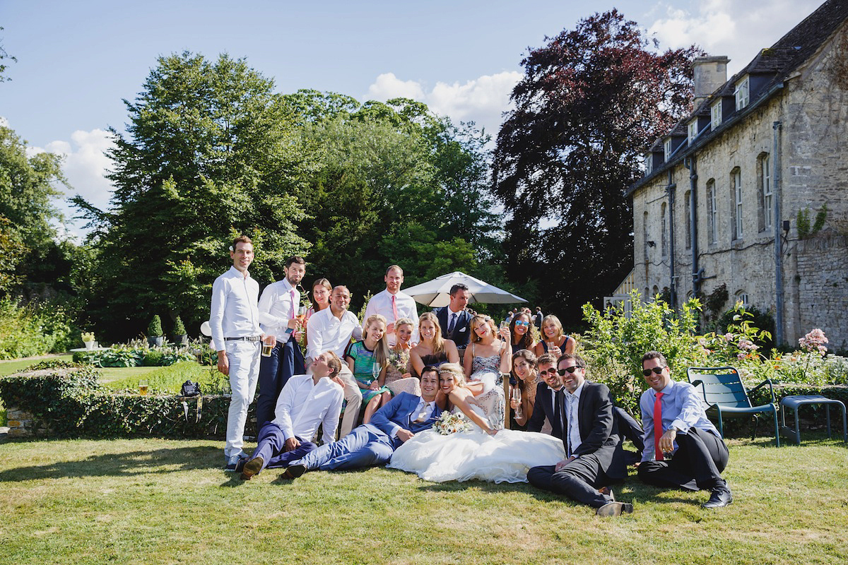 Victoria wears a Pronovias gown with a cathedral length veil for her relaxed, fun and colourful English country garden wedding in the Cotswolds. Photography by Sarah Ann Wright.