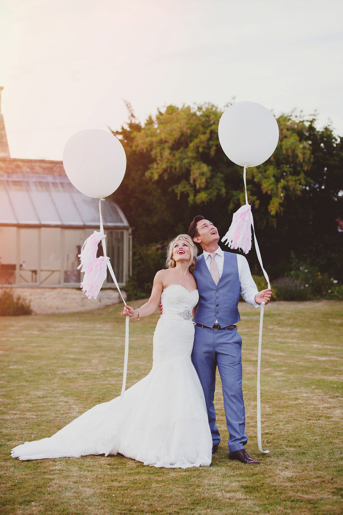 Victoria wears a Pronovias gown with a cathedral length veil for her relaxed, fun and colourful English country garden wedding in the Cotswolds. Photography by Sarah Ann Wright.