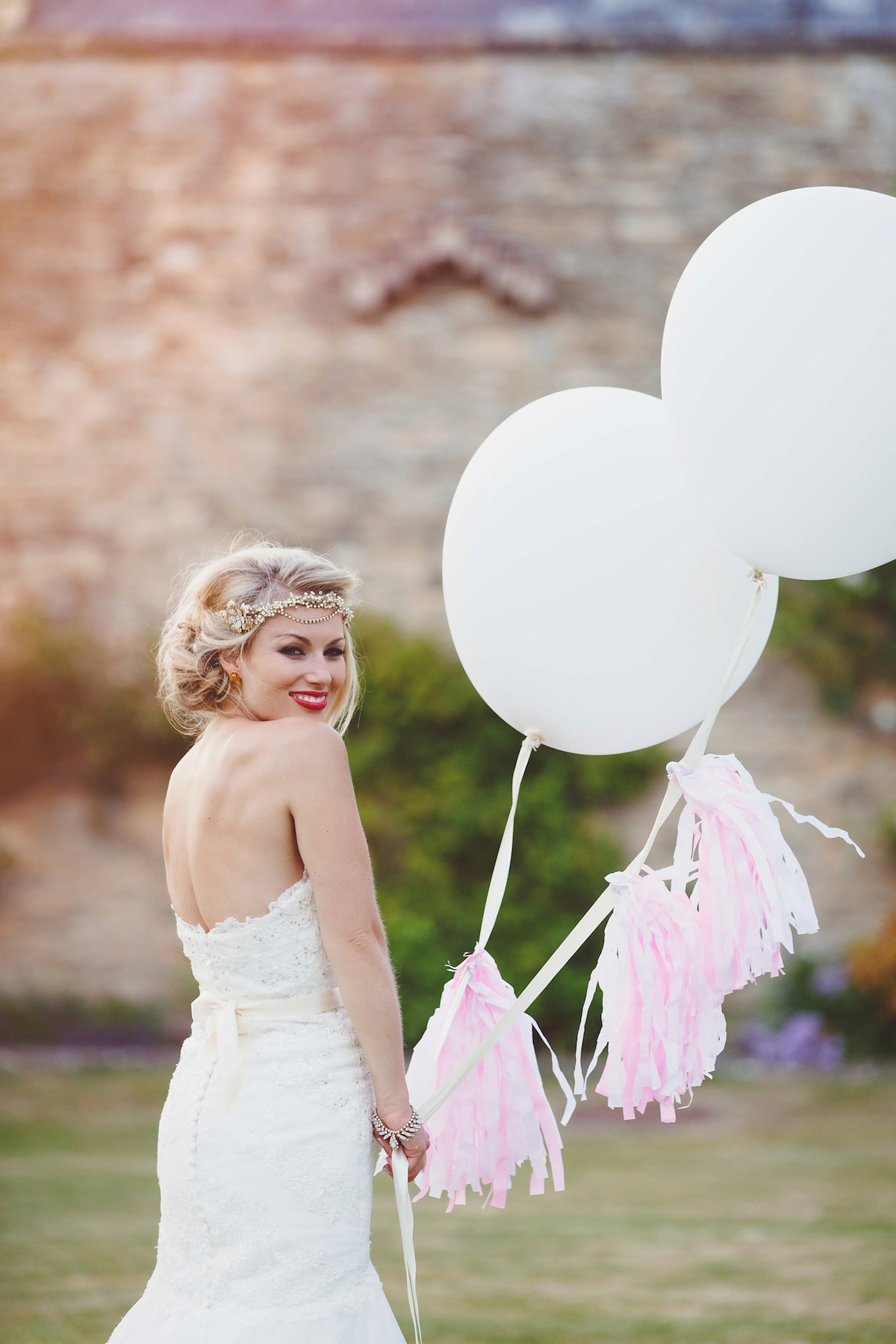 Victoria wears a Pronovias gown with a cathedral length veil for her relaxed, fun and colourful English country garden wedding in the Cotswolds. Photography by Sarah Ann Wright.