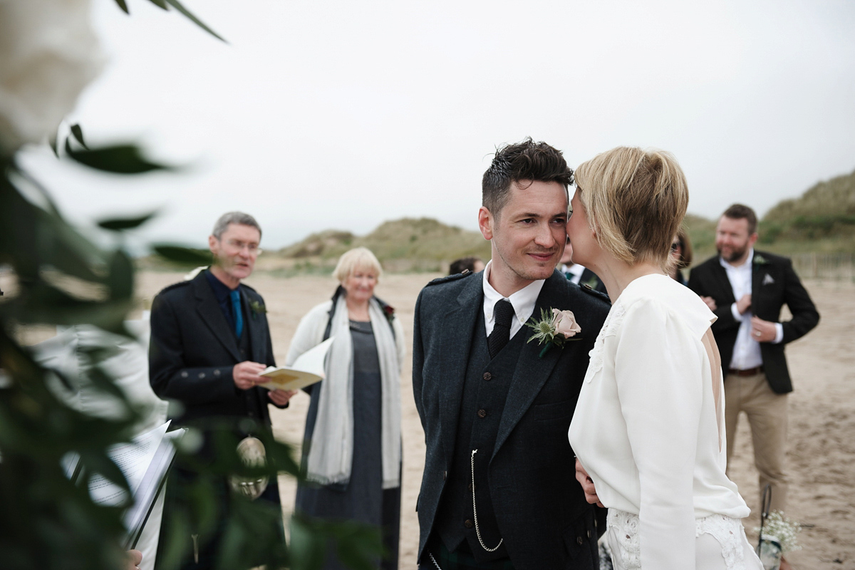 Laura wears a 1970's inspired Stone Cold Fox wedding dress for her laid back and organic beach wedding in Scotland. Photography by Tino and Pip.